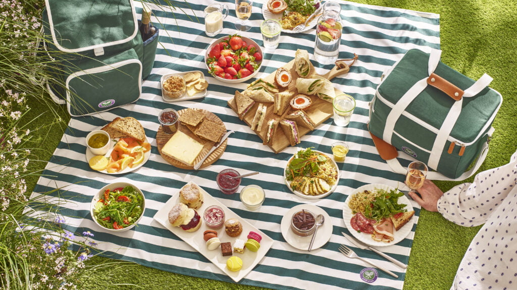 Picnic hamper with stripy picnic blanker and spread of gourmet foods