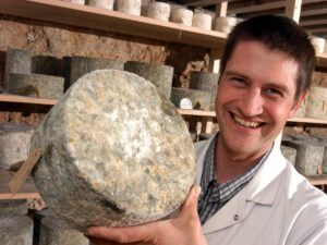 Cheese maker with aged wheel of cheese